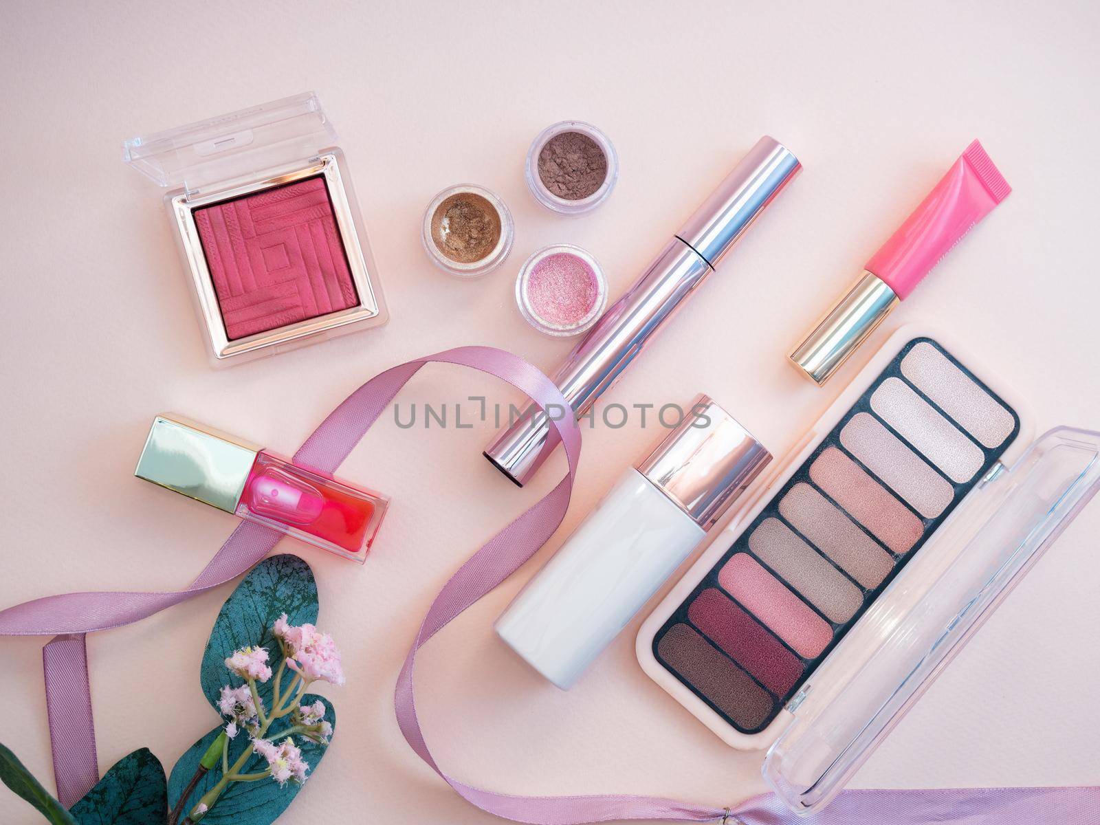 set of beauty cosmetics for female face and eye makeup on pink background . photo