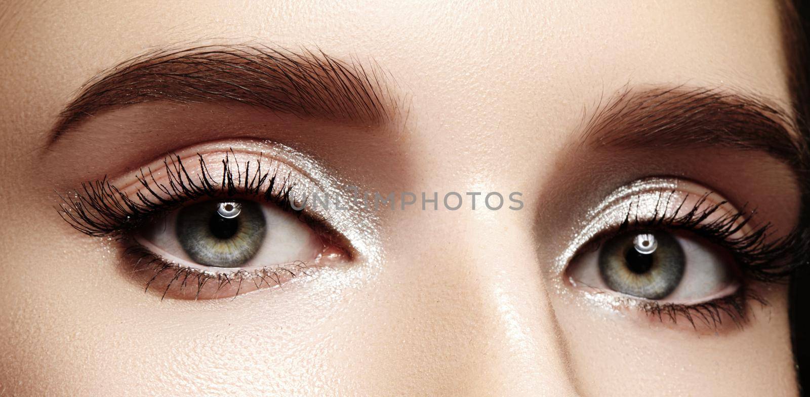 Closeup female eyes with bright make-up, great shapes brows, extreme long eyelashes. Celebrate makeup, luxury eyeshadows by MarinaFrost