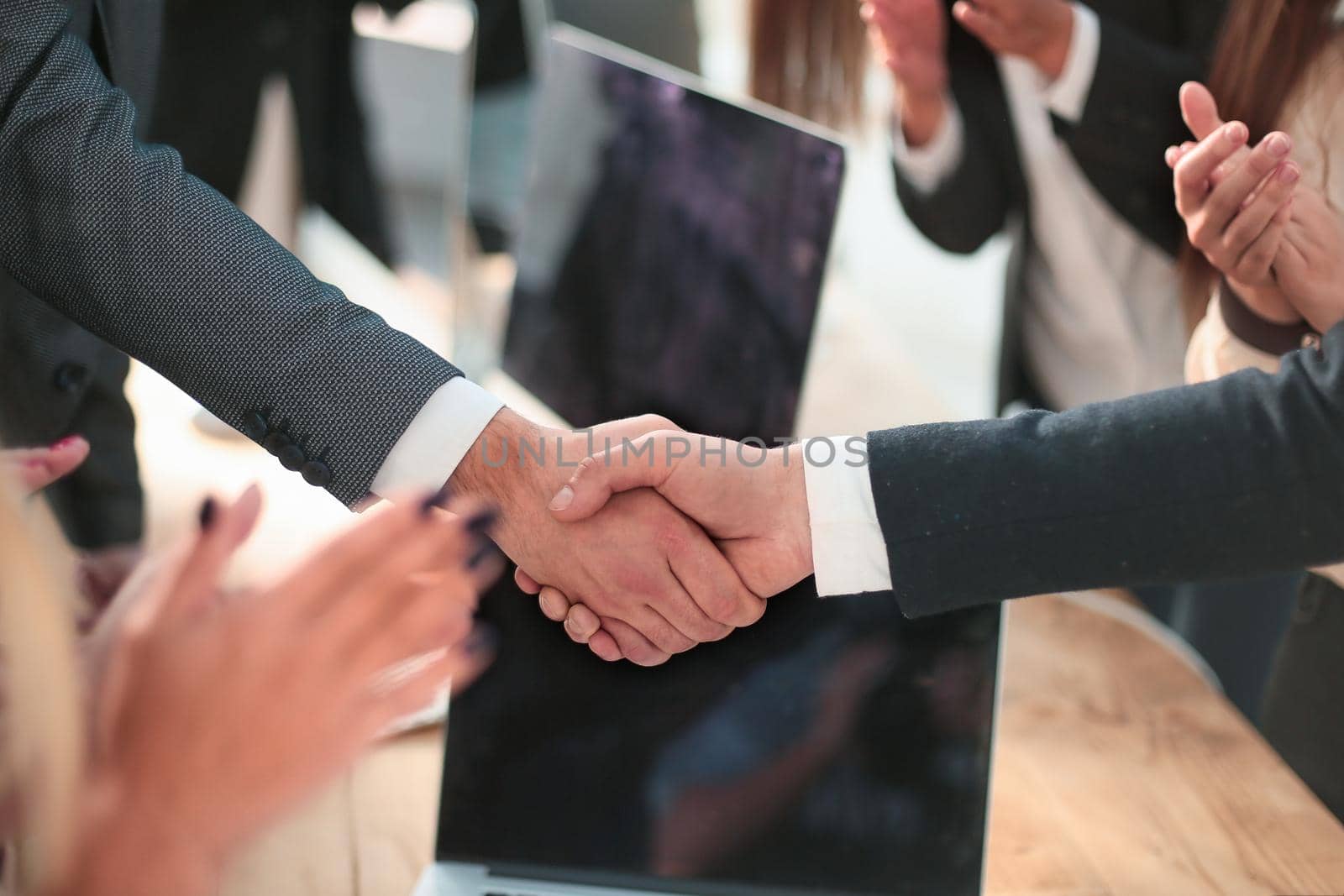 close up. smiling businessman shaking hands with his business partner