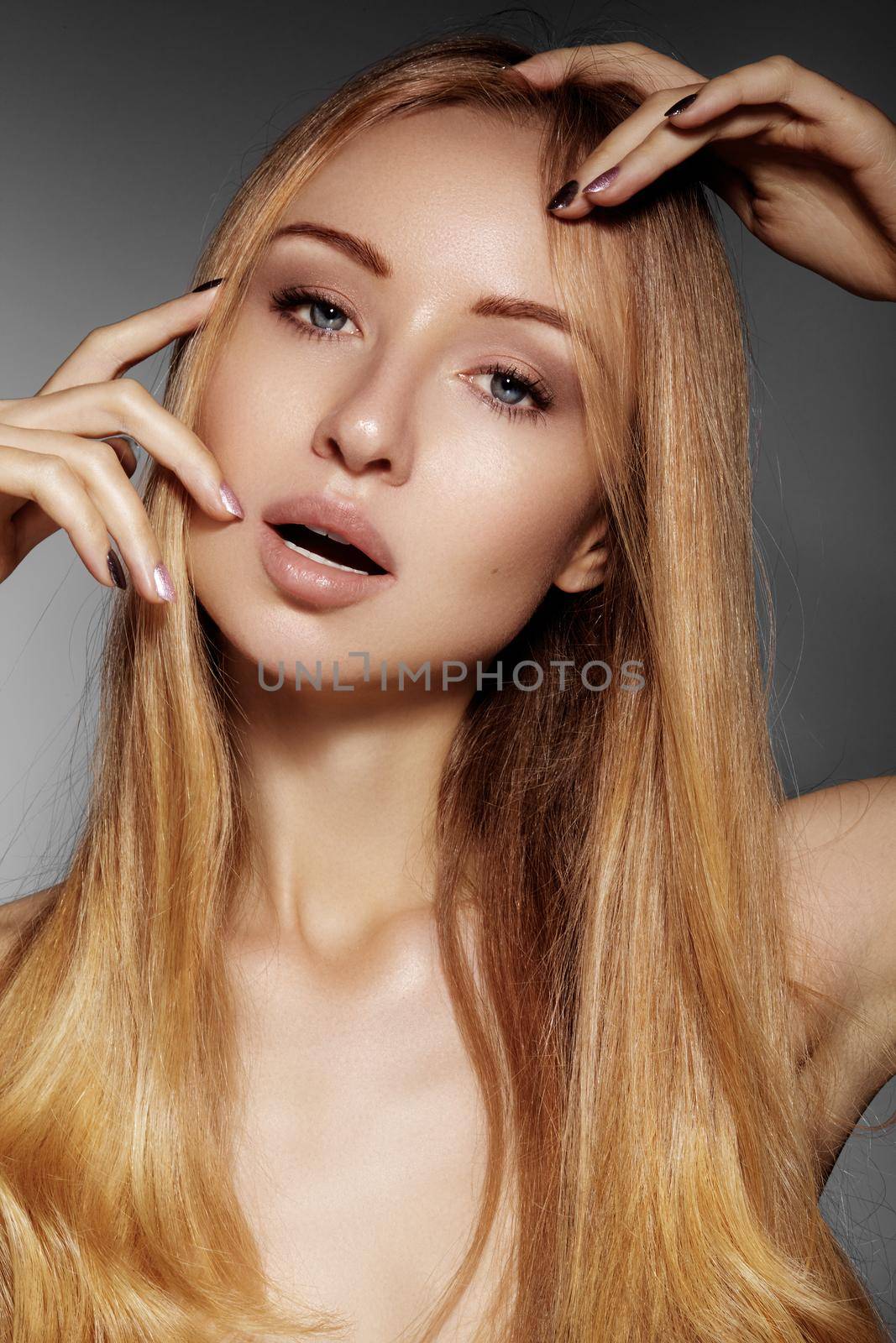 Beautiful young woman with clean skin, beautiful straight shiny hair, fashion makeup. Glamour make-up, perfect shape eyebrows. Portrait sexy blondy. Beautiful smooth hairstyle. Shiny nail polish.