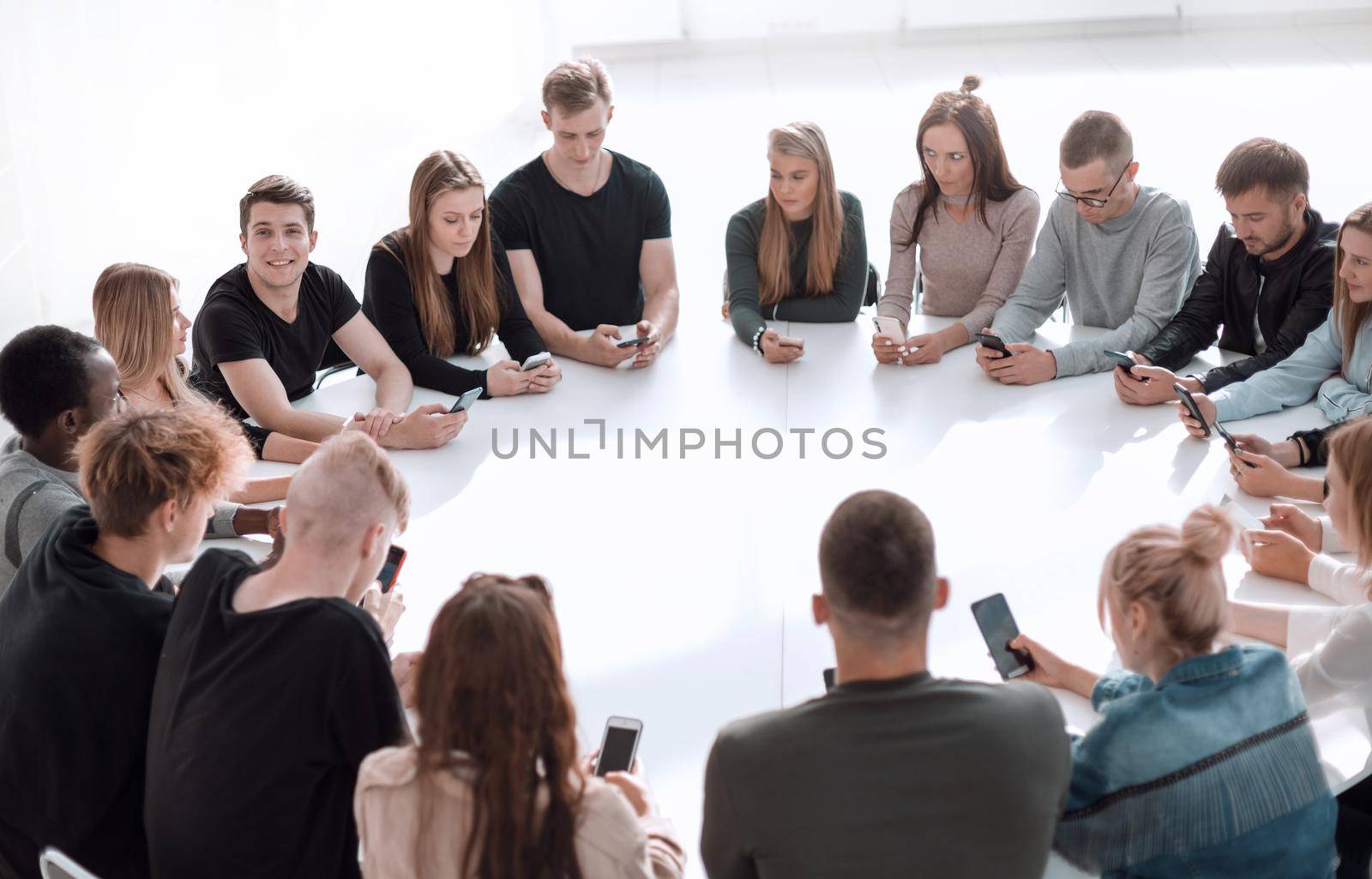 study group of young people sitting at a round table . photo with copy space