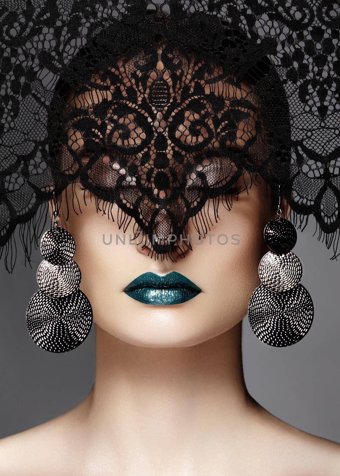 Luxury Woman with Celebrate Fashion Makeup, silver Earrings, black dramatic Lace veil. Halloween sexy witch look or luxe Christmas style. Green metallic Lips Make-up