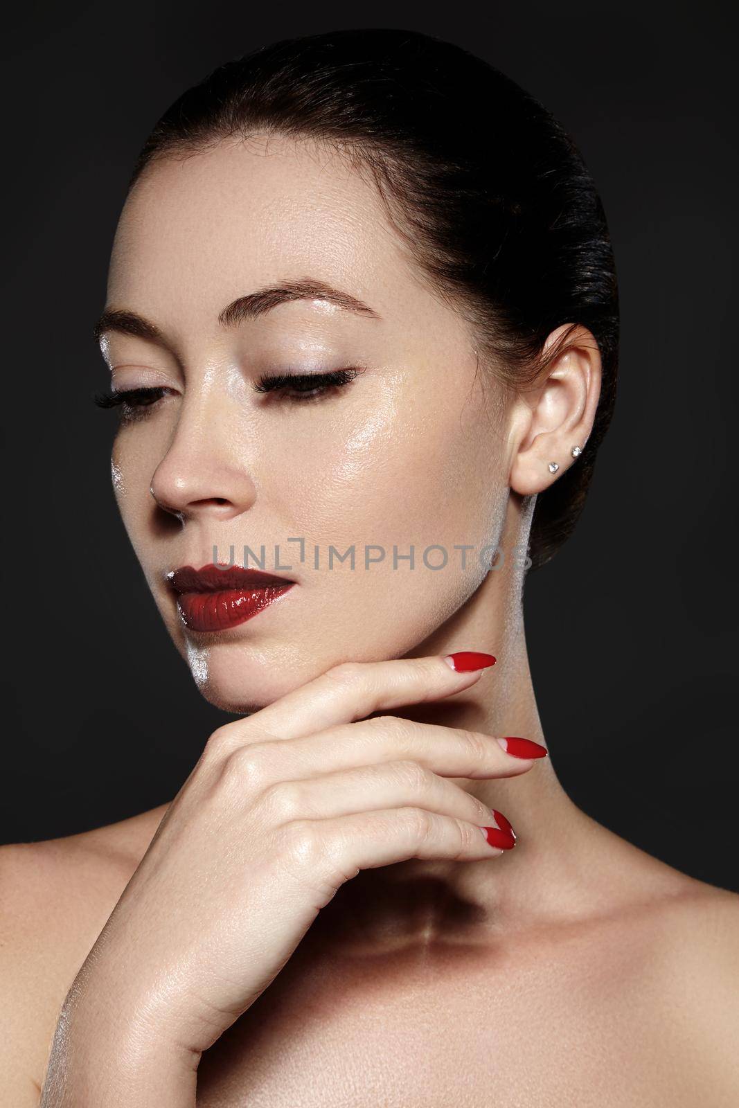 Luxury woman style vamp. Cosmetics, manicure on nails with bright red polish. Dark red lips make-up and nail color. Beauty close-up portrait of female model with red lipstick and clean skin