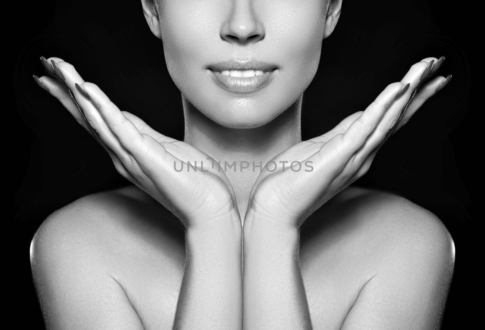 Beautiful woman show her erfect face with fashion make-up on dark grey background. Extreme eyelashes, plump lips, clean skin. Fresh spa look