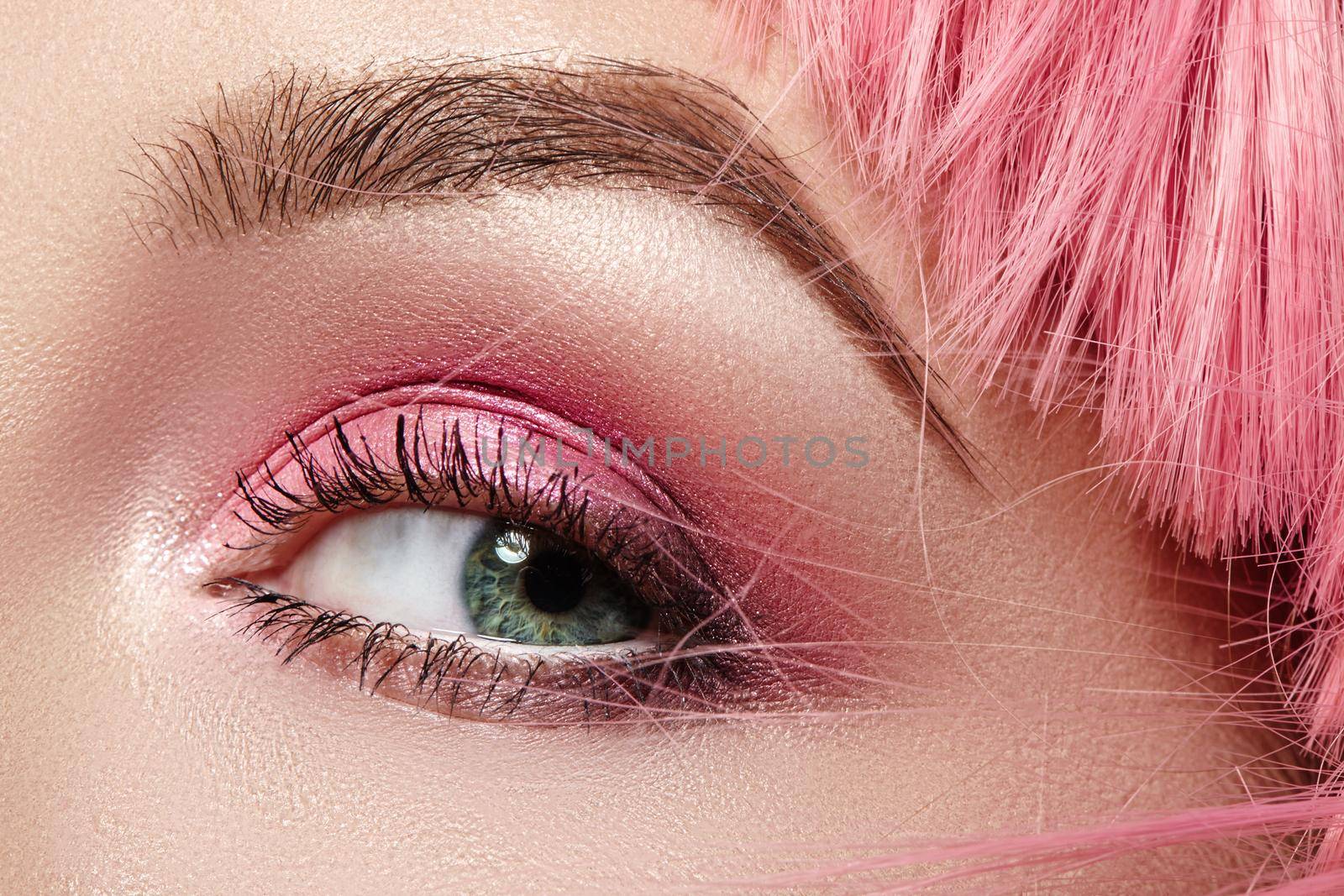 Closeup Macro of Pink Fashion Eye Make-up. Expressive Makeup, Bright Summer Eyeshadows and Magenta Color Hair, Shiny Skin