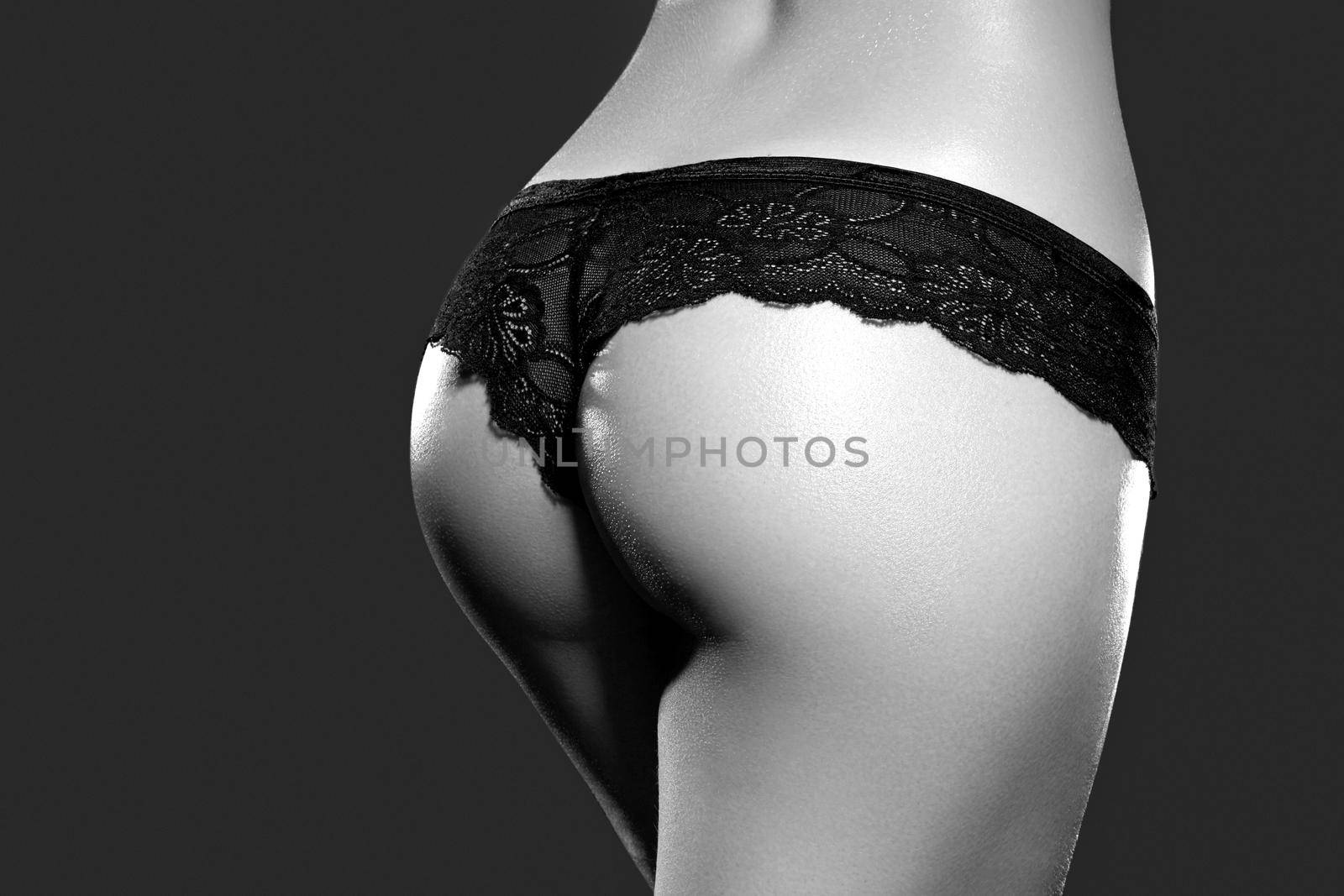 Beautiful female slim body. Beauty part of female body. Woman's shape with clean skin.Diet and fitness.Healthy lifestyle. Ideal waist, perfect buttocks and legs, sexy back. Black and white shoot