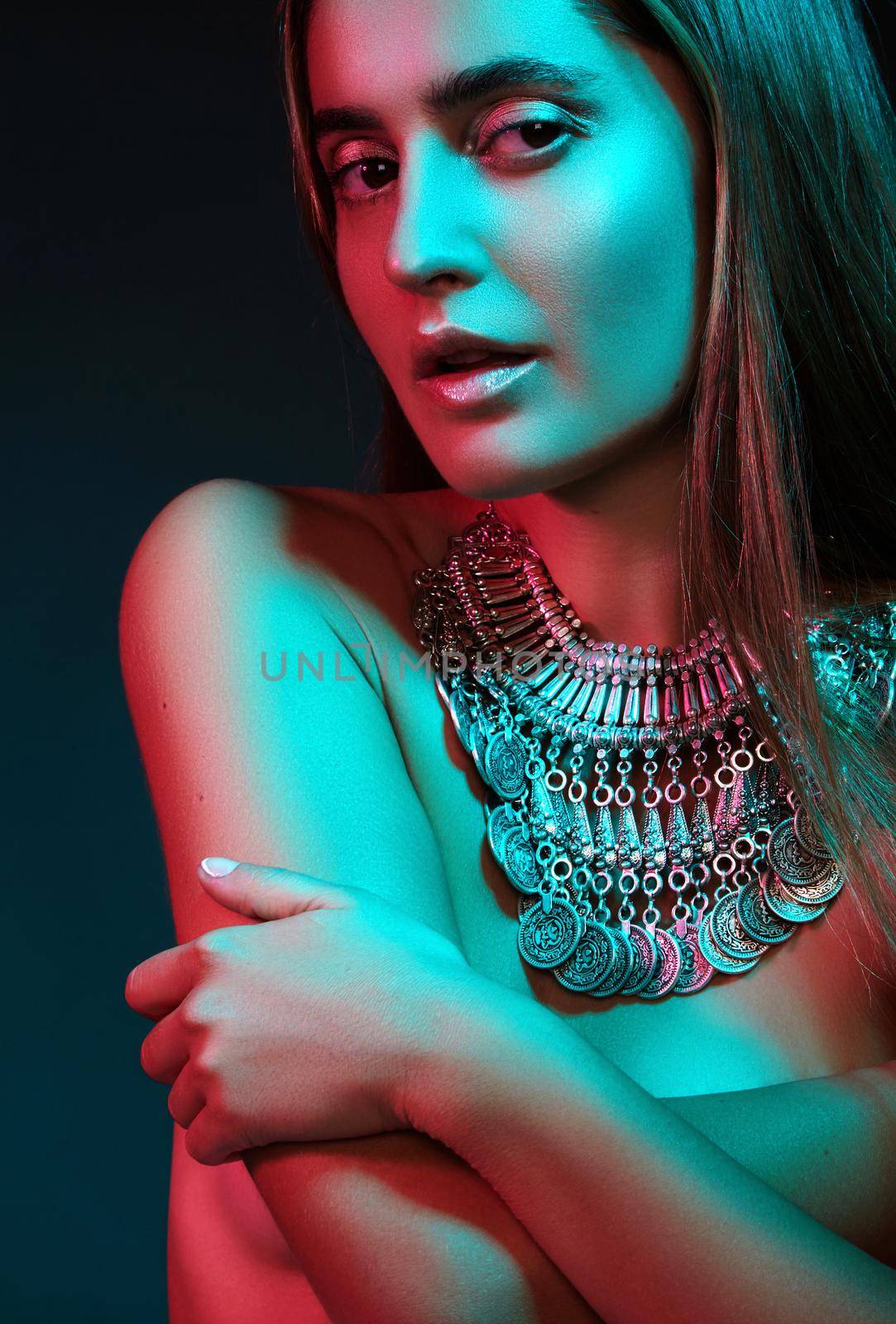 Beautiful woman in a necklace. Model in jewelry from silver. Beautiful indian jewellery. Bright lights photo effect
