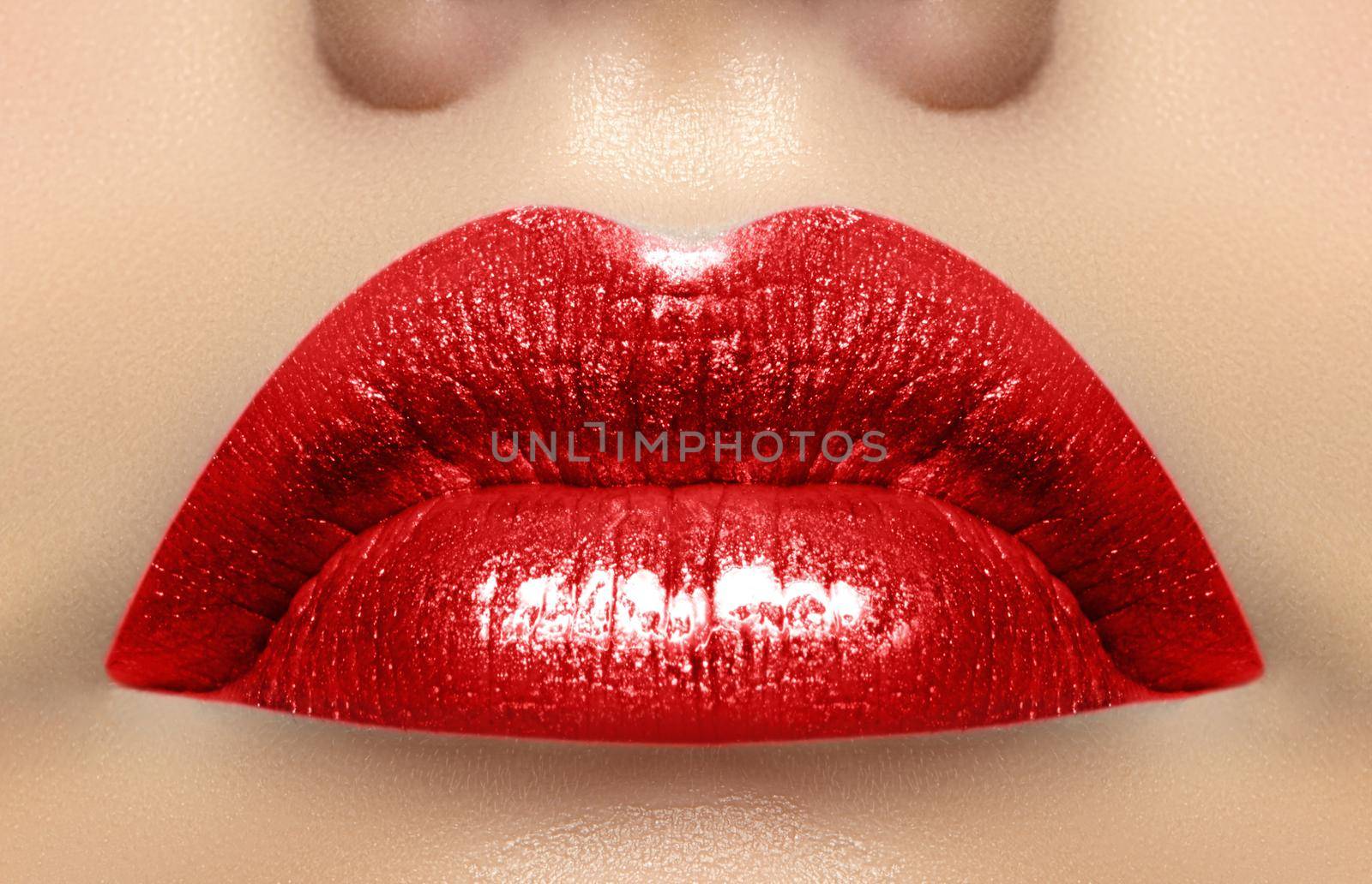 Close-up macro shot of female mouth. Sexy Glamour red lips Makeup with sensuality gesture. Magenta gloss lipstick. Full lips