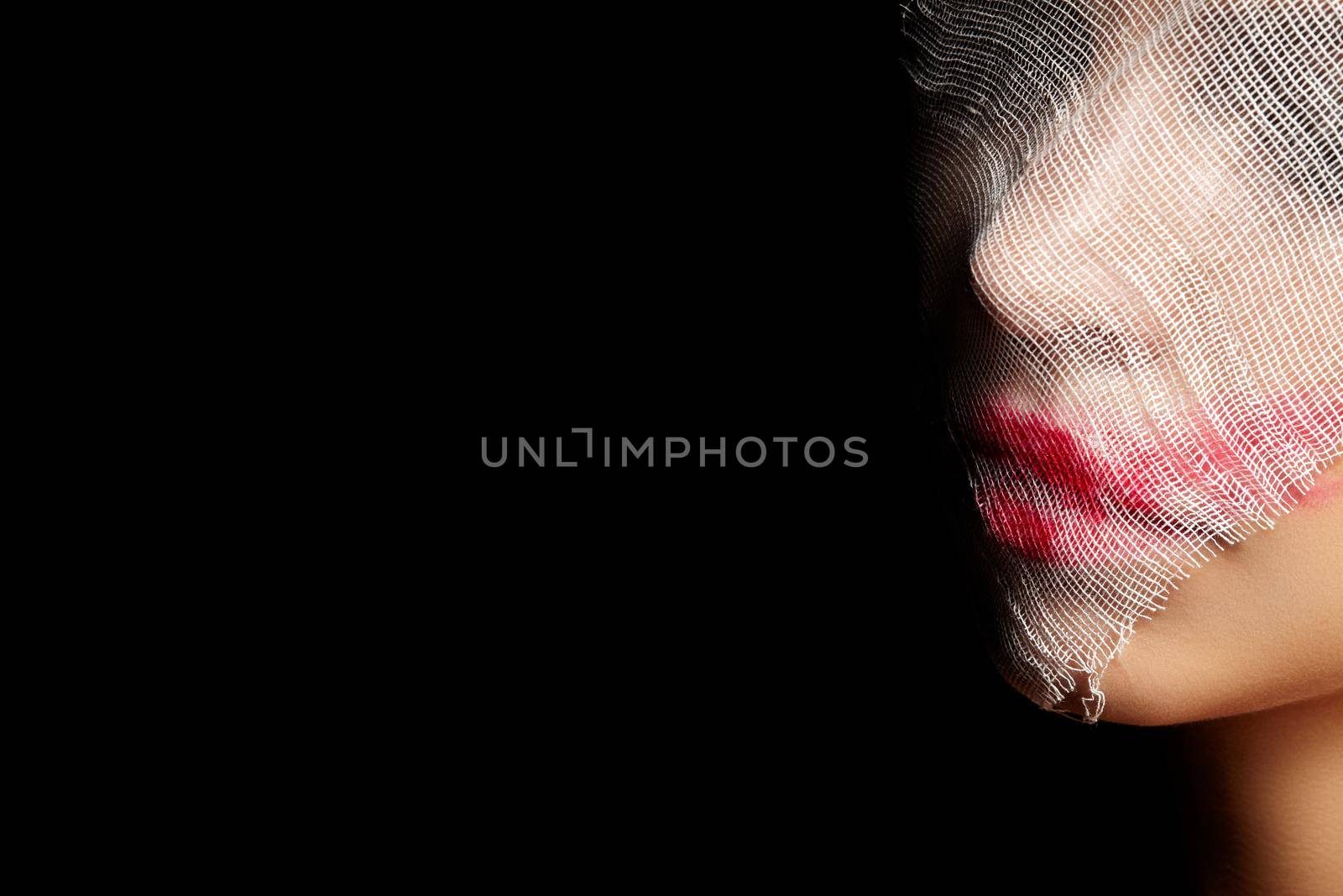 Girl in Glamorous Joker Mask for Halloween. Woman Face Wrapped in Bandage with Art Make-up. Creative Masquerade Style. Plastic Surgery