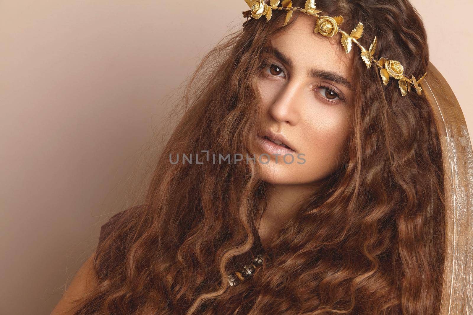 Beautiful Woman. Curly Long Hair. Fashion Model with Healthy Wavy Hairstyle. Accessories. Boho Girl with Autumn Wreath, Gold Floral Crown. Horizintal shot