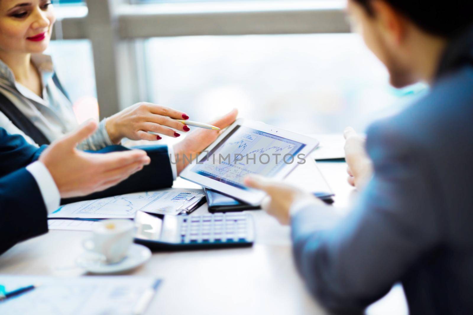 Image of human hand pointing at touchscreen in working environment at meeting