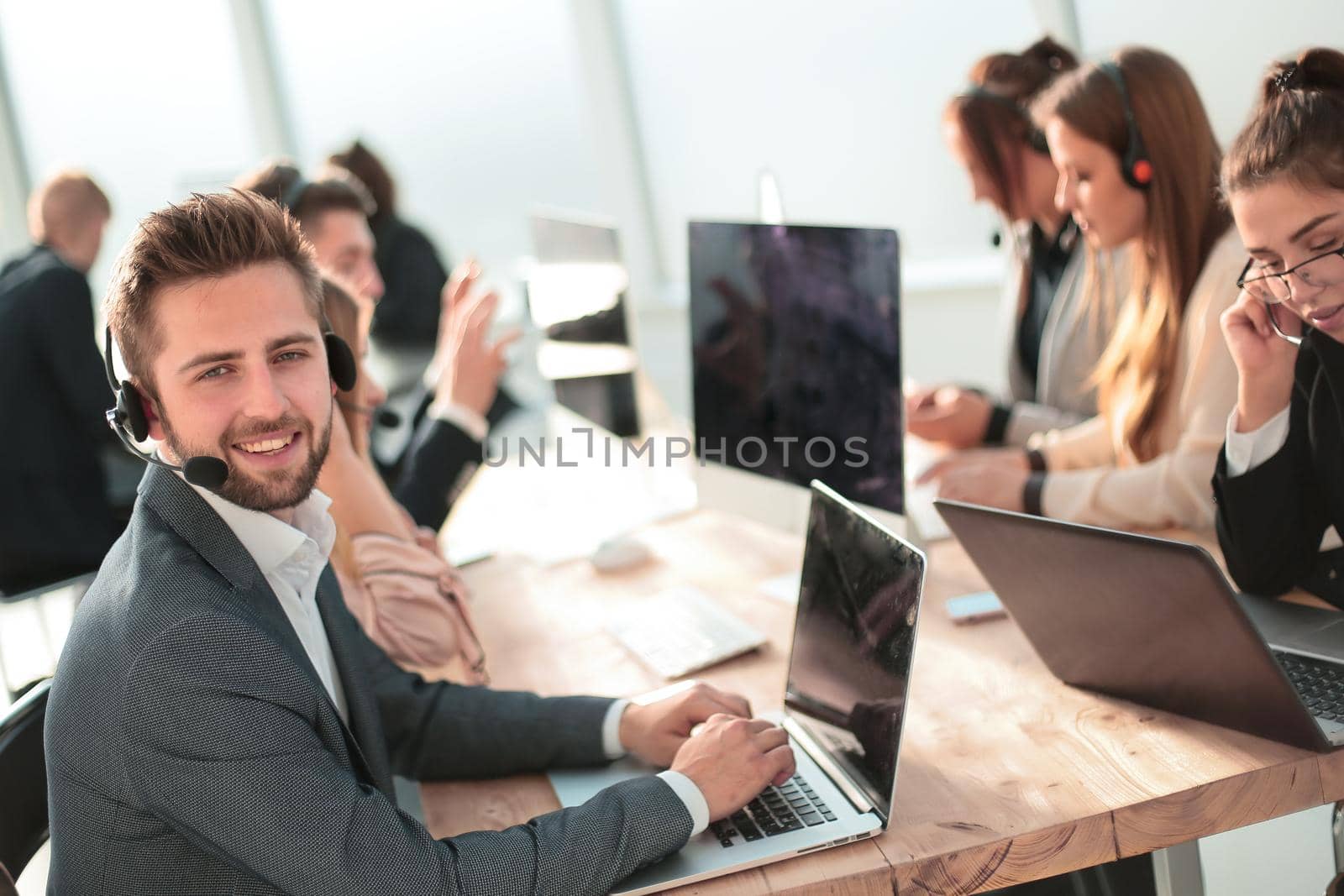 young customer service representative sitting behind a Desk. photo with copy-space