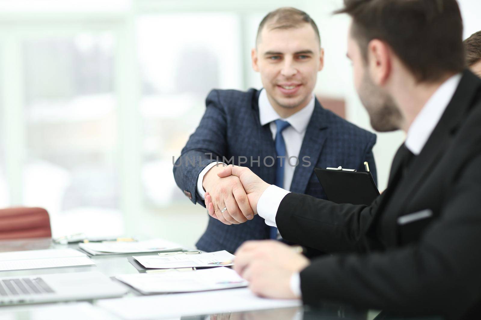 handshake trading partners at the Desk in the office.