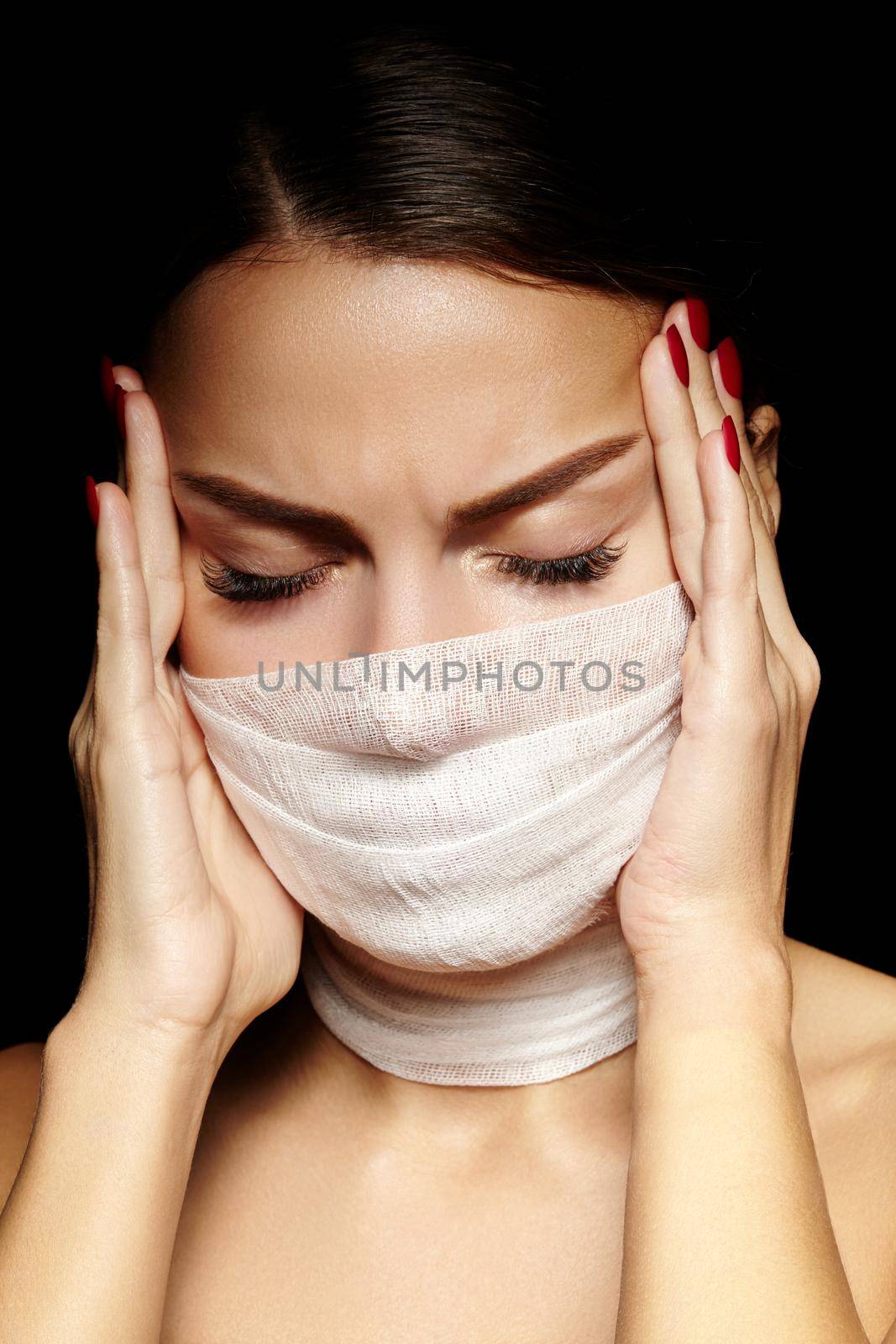 Beautiful woman with a bandage mask on face. Fashion eye make-up. Beauty plastic surgery or protection hygiene in viral covid-19 pandemic