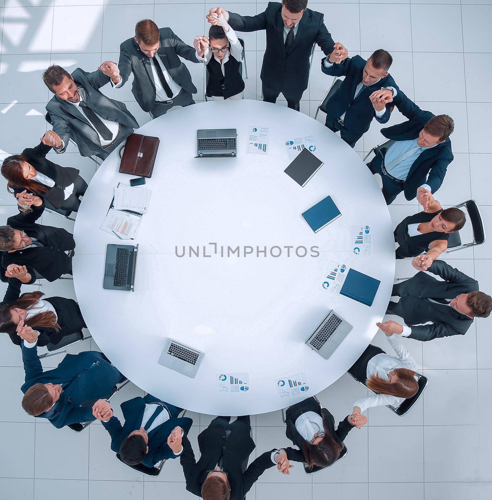 view from the top.large business team sitting at the round table and raising his hands up. the business concept