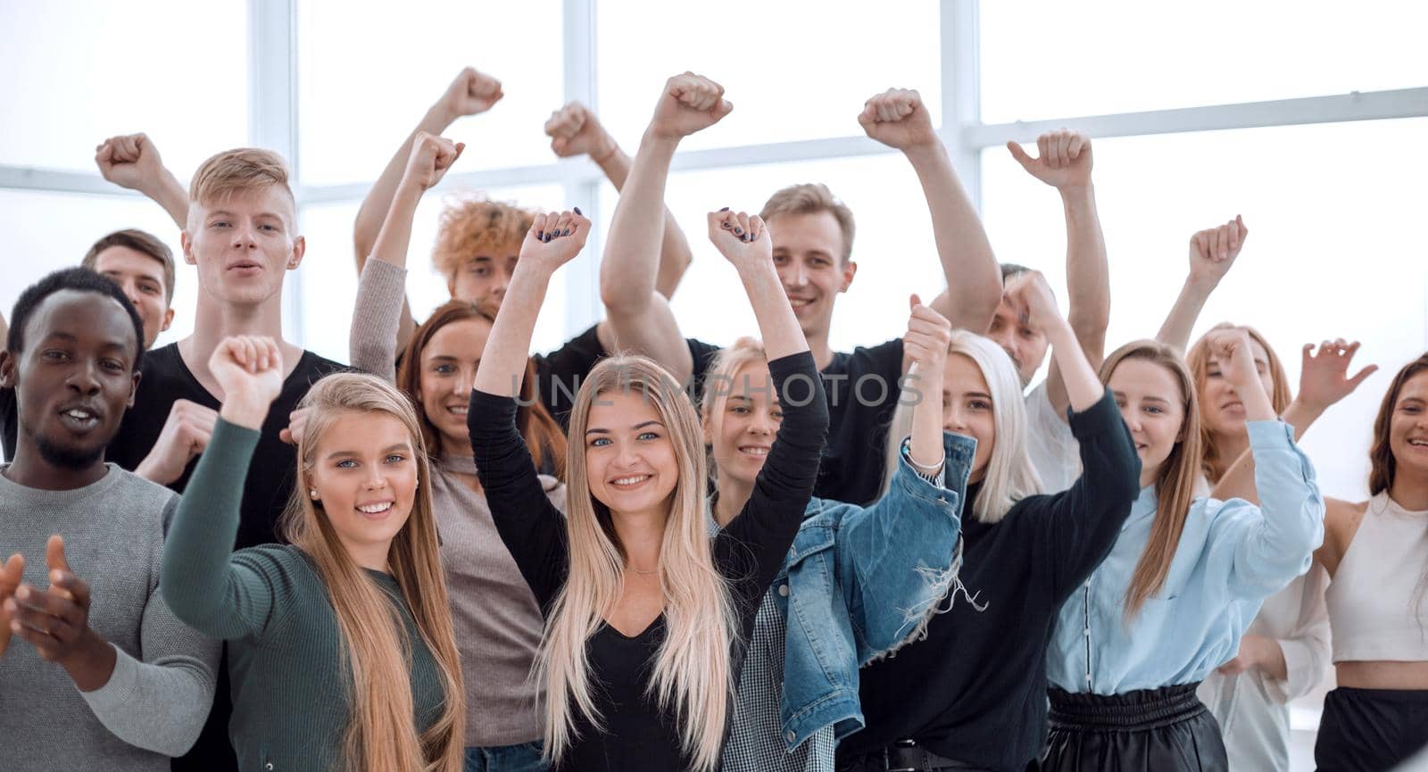 close up. group of smiling young people showing their success. isolated on white
