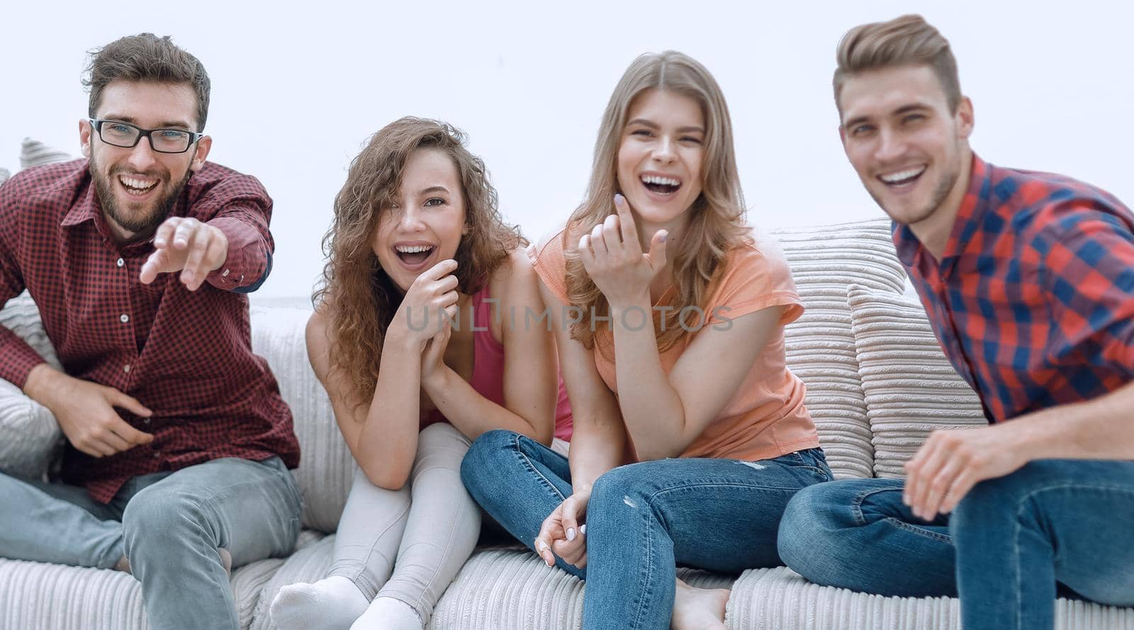 group of cheerful friends watching their favorite movie, sitting on the couch