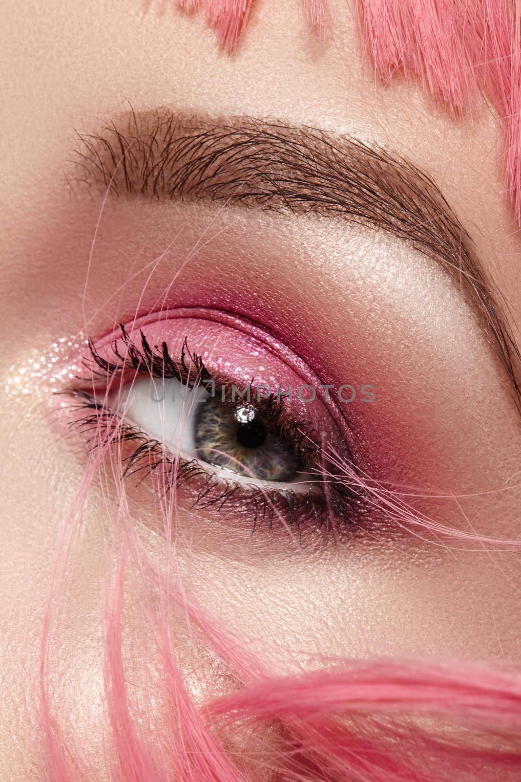 Closeup Macro of Pink Fashion Eye Make-up. Expressive Makeup, Bright Summer Eyeshadows and Magenta Color Hair, Shiny Skin