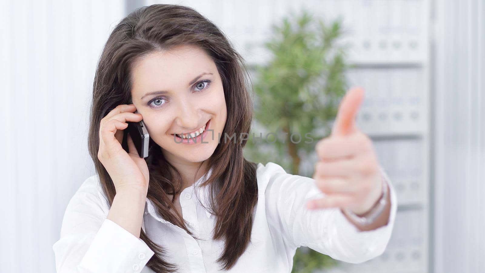 successful business woman showing thumb up sitting on her Desk.photo with copy space