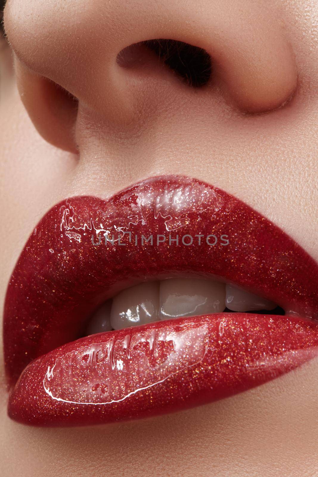Close-up of female lips with bright makeup. Macro of woman's face. Fashion lip make-up with red gloss.Red lipgloss makeup on full female lips