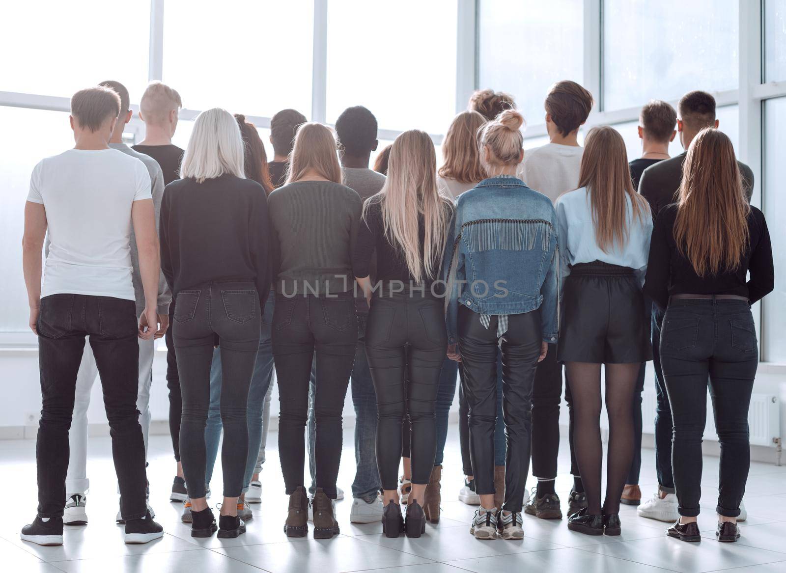 large group of young people looking at a large white screen by asdf