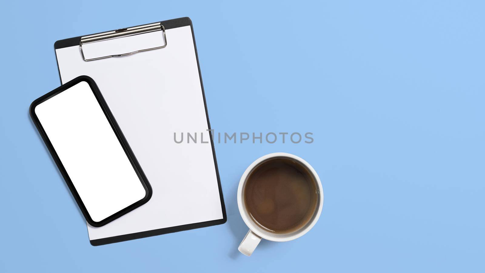 Top view mockup smart phone, clipboard and coffee cup on blue background. Copy space, blank screen for advertise text.