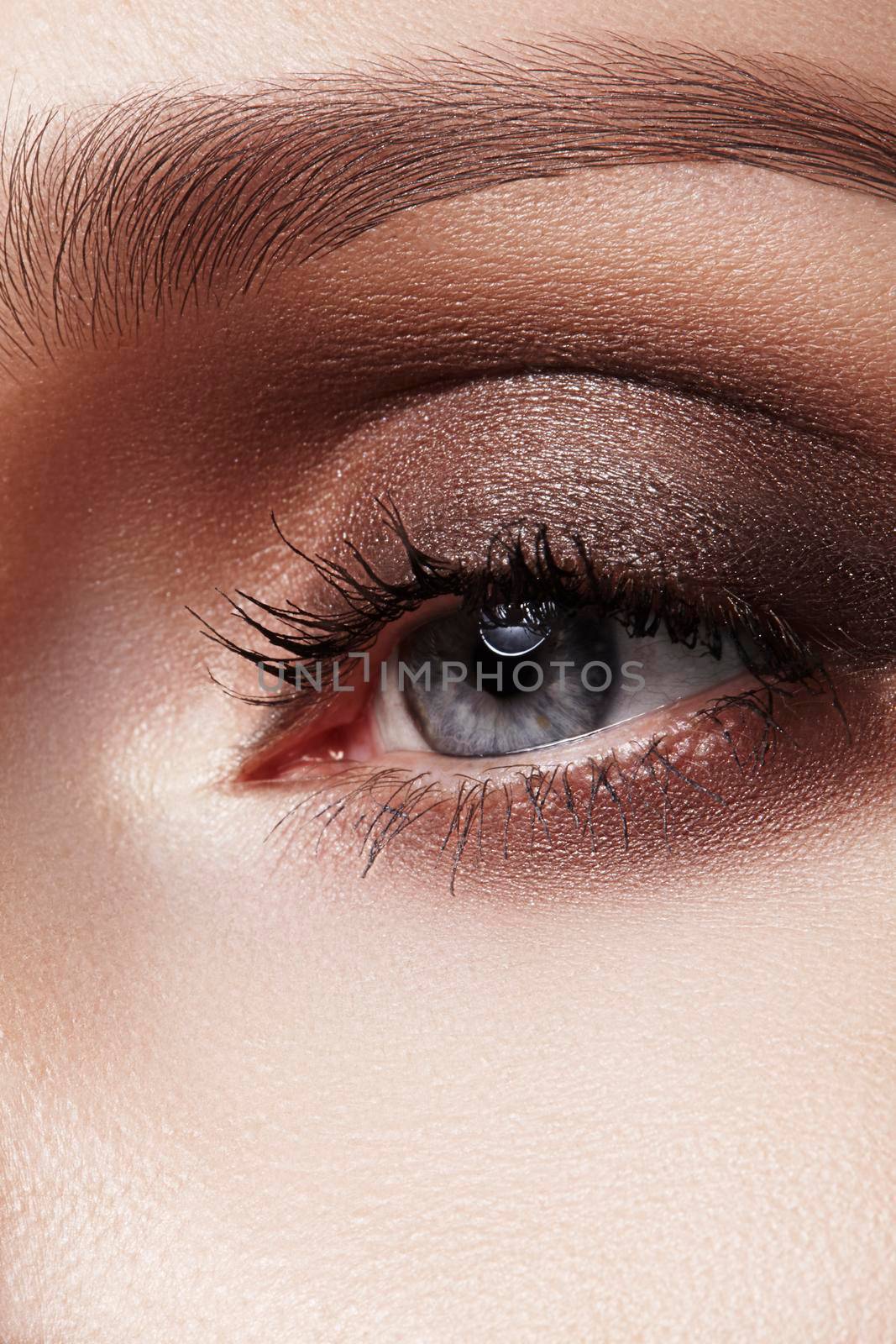 Close-up macro of beautiful female eye with perfect shape eyebrows. Clean skin, fashion naturel make-up. Good vision.