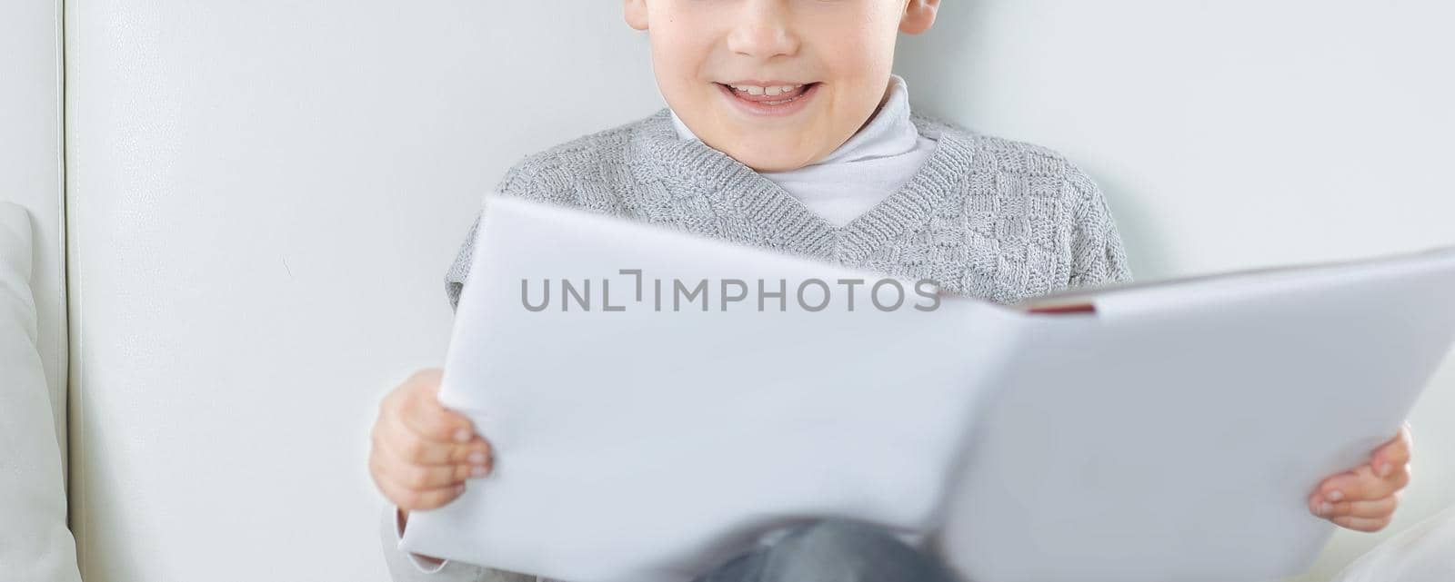 boy reads a book on the couch in the nursery.photo with copy space.