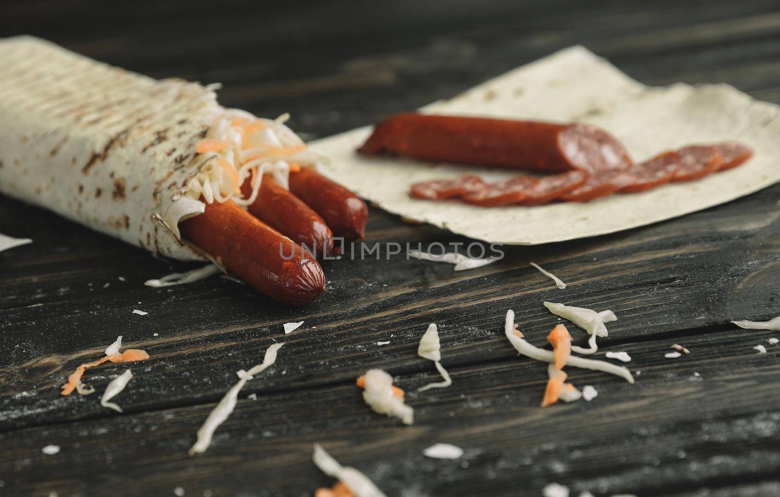 smoked sausage in pita bread on a wooden table.