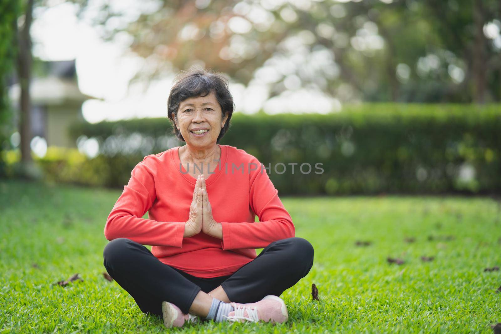 Senior asian woman practicing yoga lesson, breathing, meditating in garden. Working out, Well being, wellness concept by Wmpix