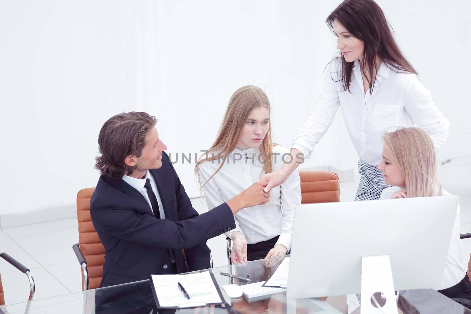 Friendly smiling businessman and businesswoman handshaking over the office desk after pleasant talk