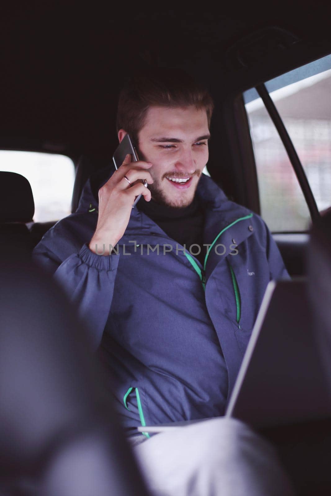 closeup. business man uses a laptop and mobile phone sitting in the car