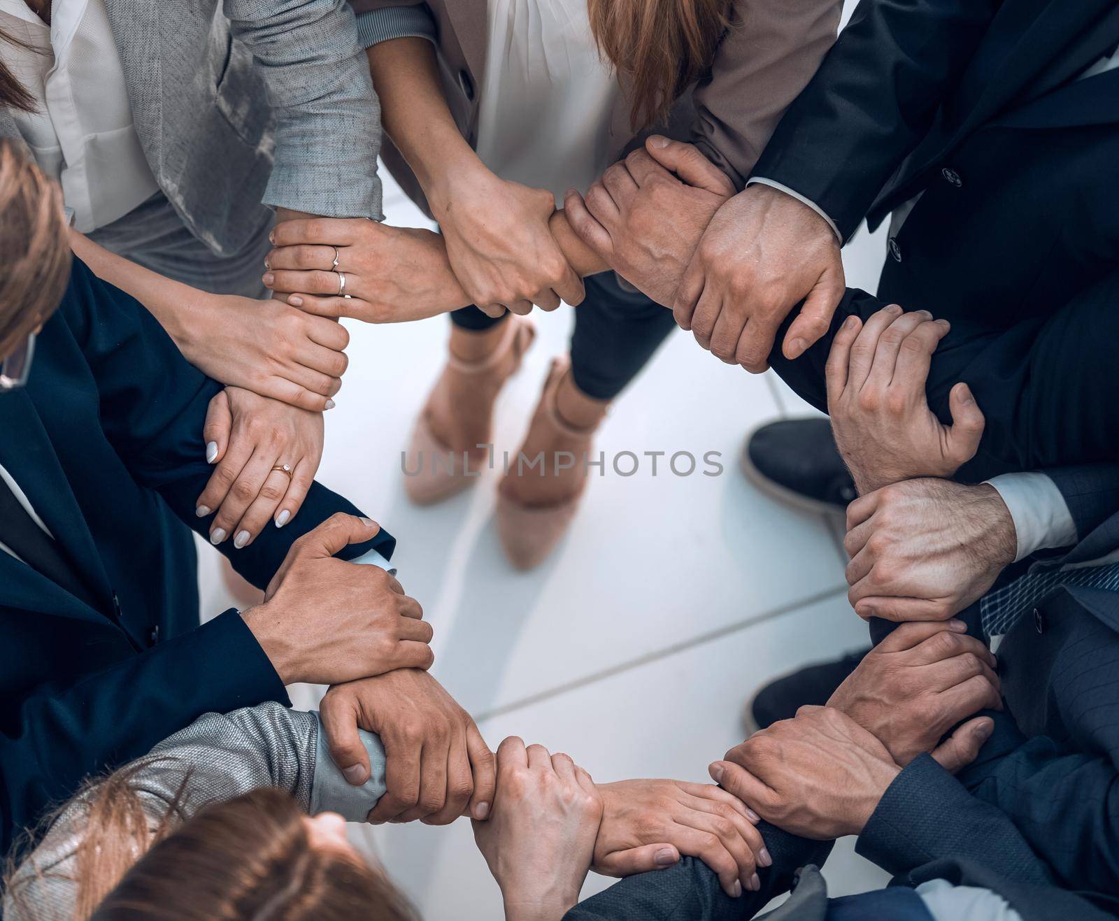 group of employees forming a circle out of hands.the concept of team building