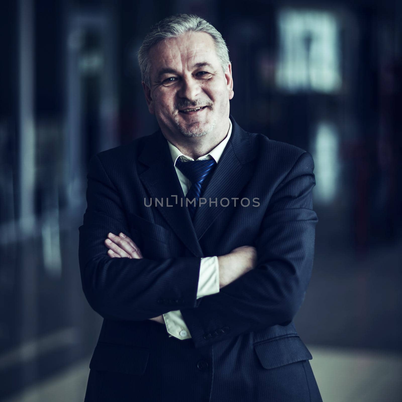 successful businessman in a business suit on background of modern office