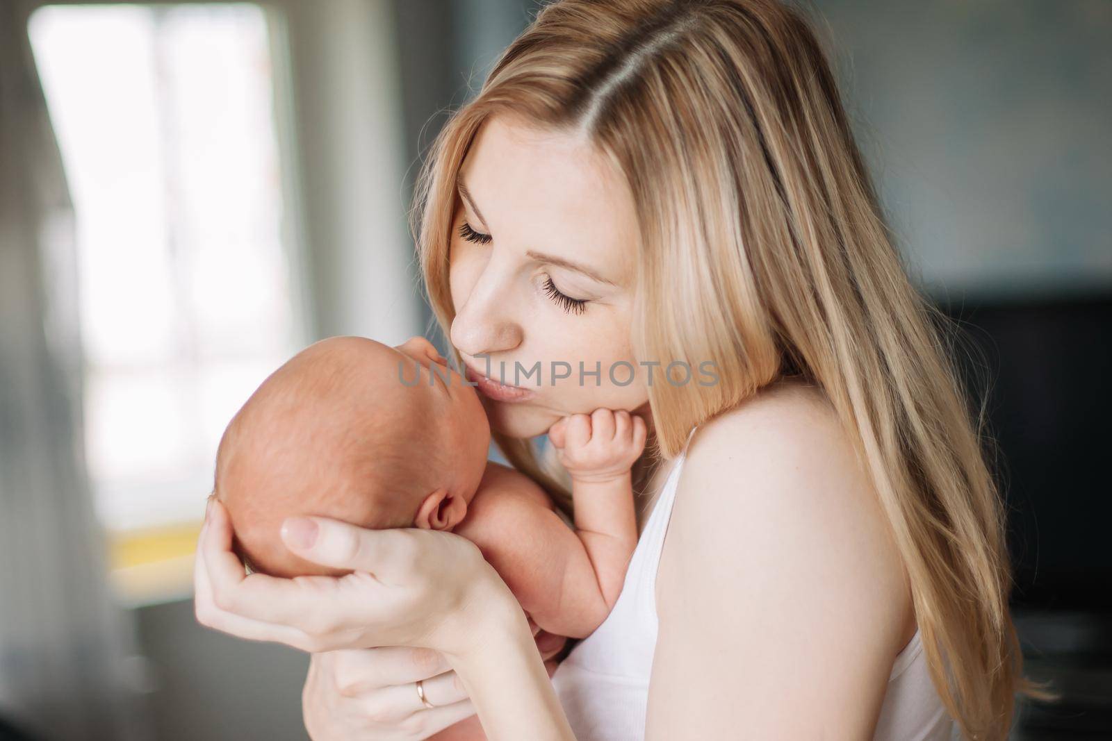 happy mom with newborn baby standing in the room. the concept of motherhood