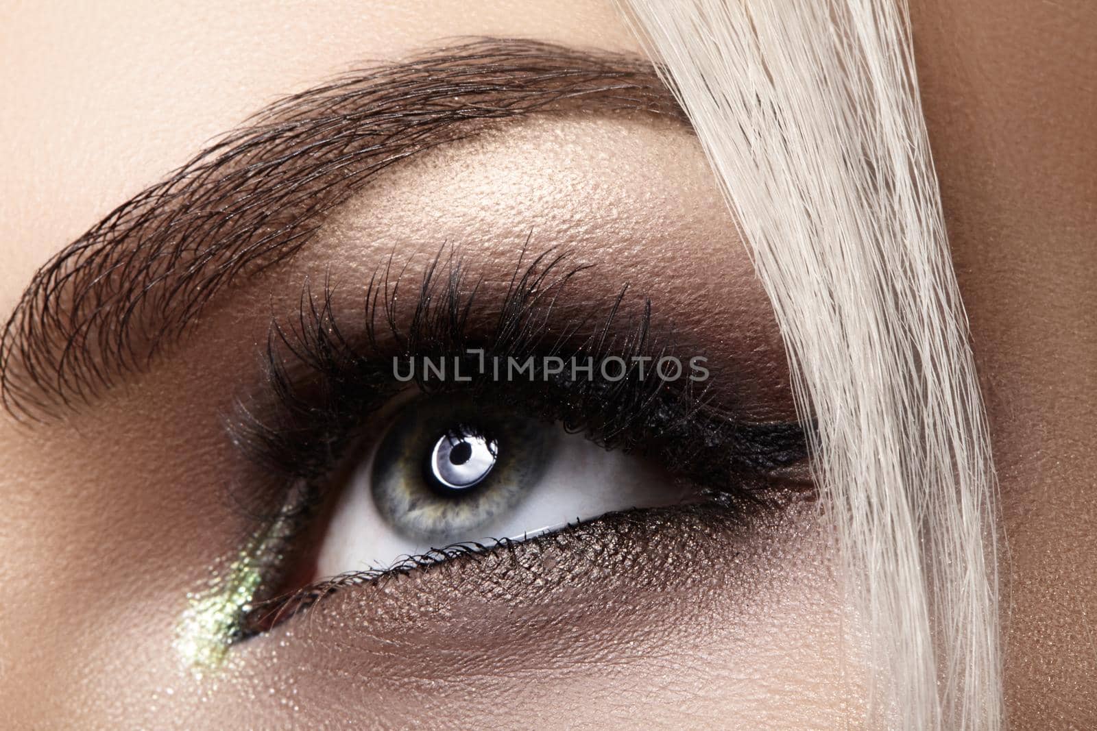 Beautiful macro shot of female eye with extreme long eyelashes and black liner makeup. Perfect shape make-up and long lashes. Cosmetics and make-up. Closeup macro shot of fashion eyes visage