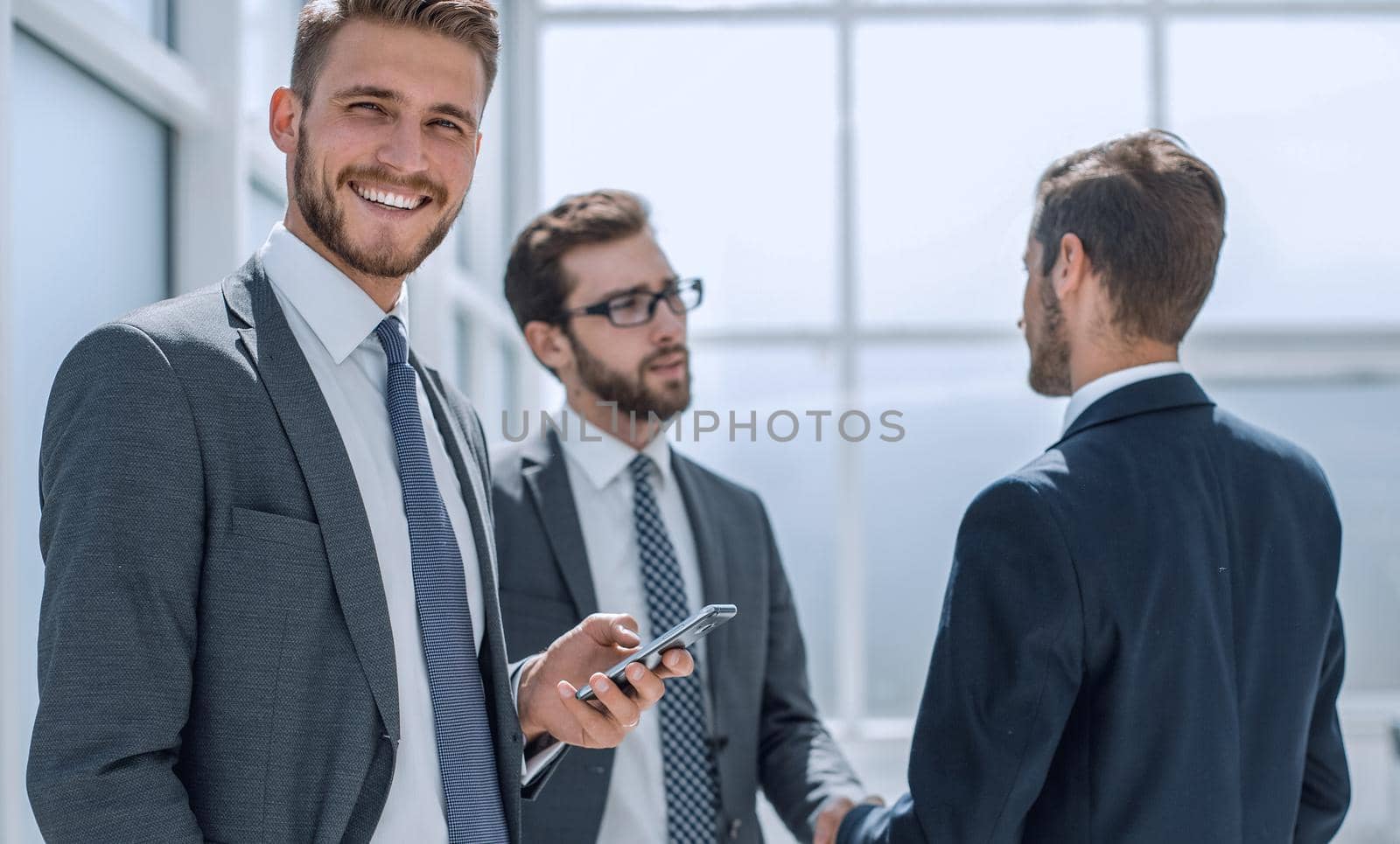 smiling businesswoman with smartphone standing in the office .business concept