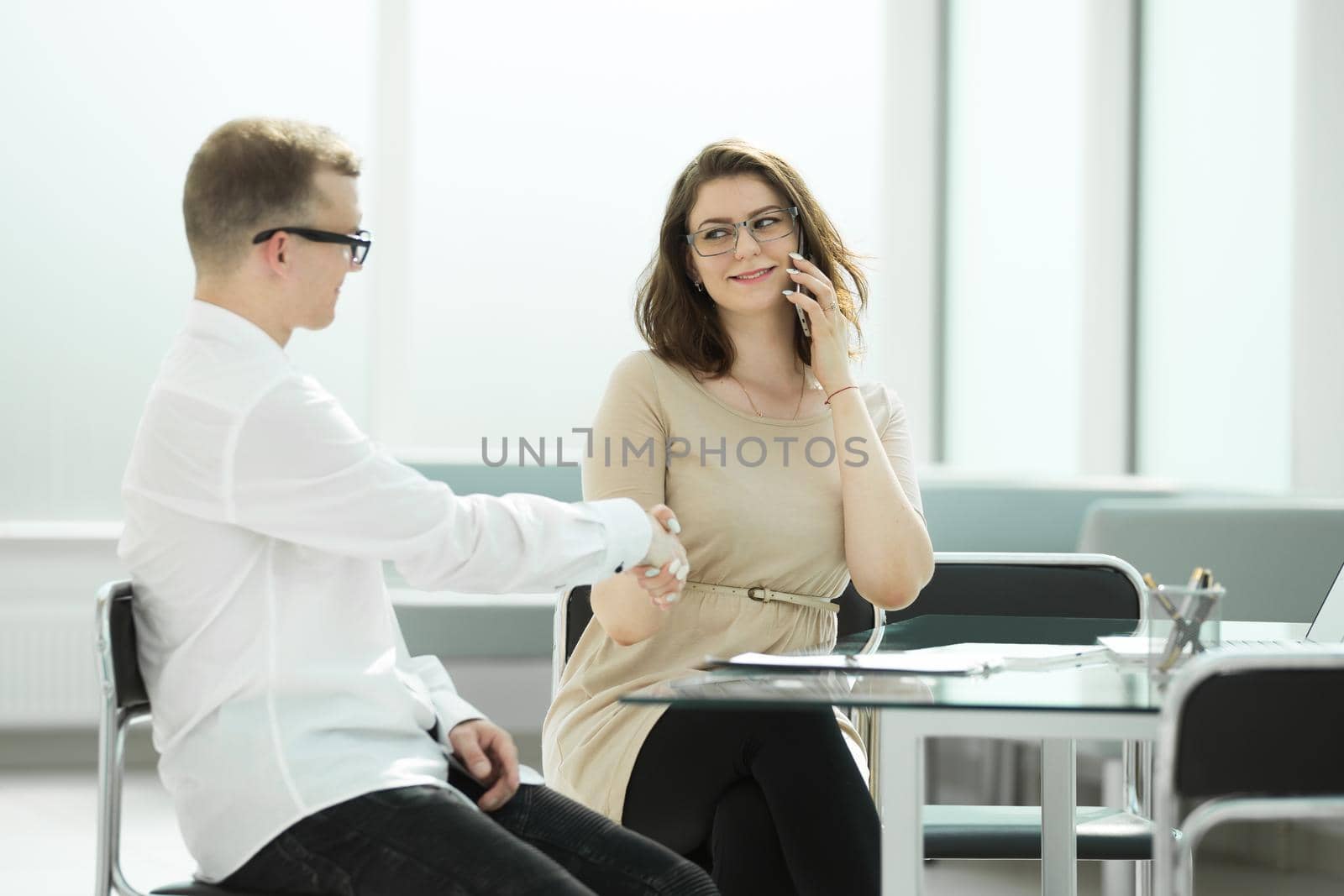 side view.handshake businessman and businesswoman at the office Desk by SmartPhotoLab