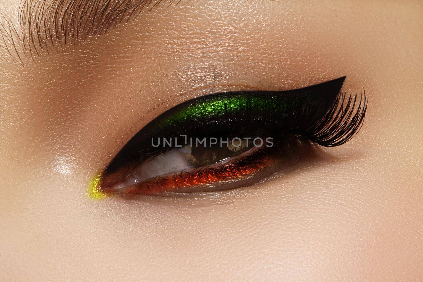 Close-up photo of female eyes with black eye liner. Fashion makeup with perfect arrows shape. Retro style and chic evening make-up. Cosmetics and make up.