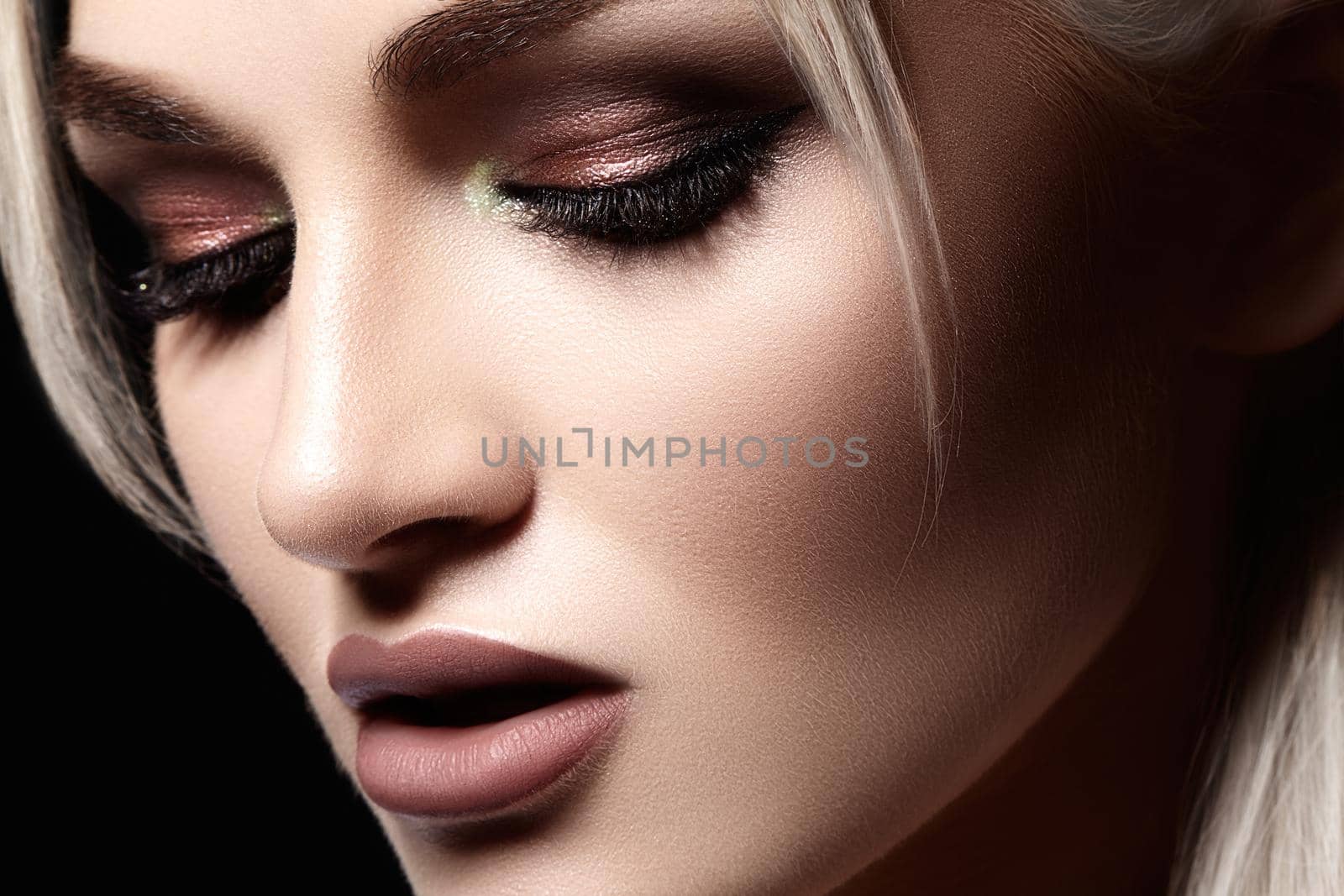 Closeup portrait with of beautiful woman face. Fashion makeup, clean shiny skin. Makeup and cosmetic. Beauty style on model face. Blond hair style
