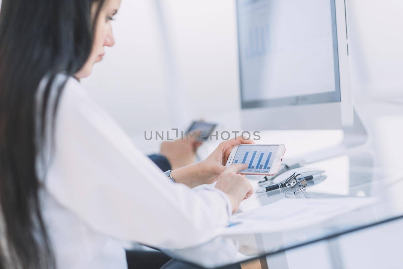 close up.the businesswoman uses her smartphone to work with financial data.people and technology