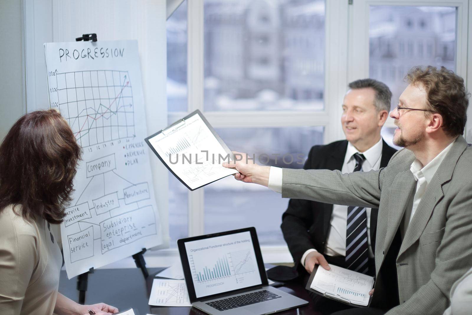 business team and investors discussing the company's profit in a modern office