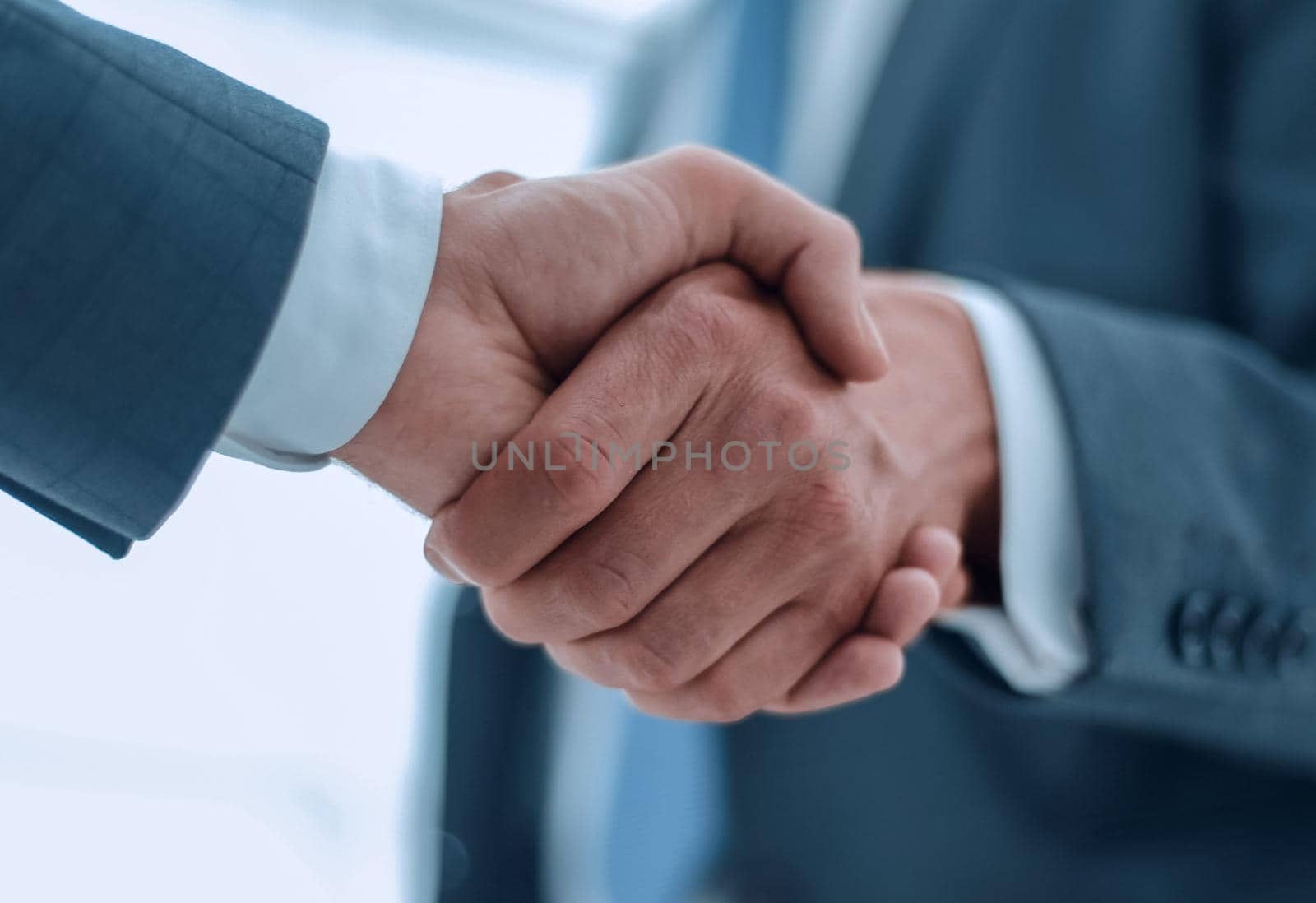 close up.strong handshake of business people.isolated on light background