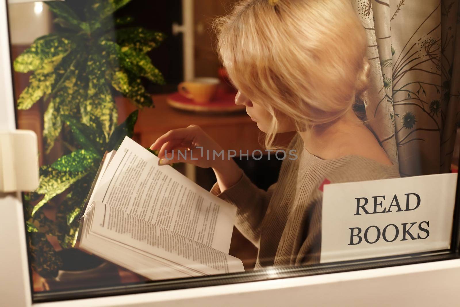 Education and rest at home. Be Healthy, Stay Home. Blond woman reads book. Self isolating while quarantine concept
