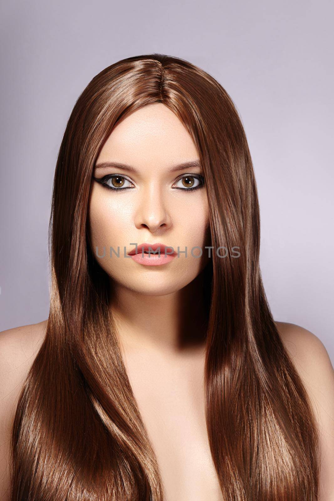 Beautiful yong Woman with Long Straight Brown Hair. Sexy Fashion Model with Smooth Gloss Hairstyle. Keratine Treatment. Vertical studio shot