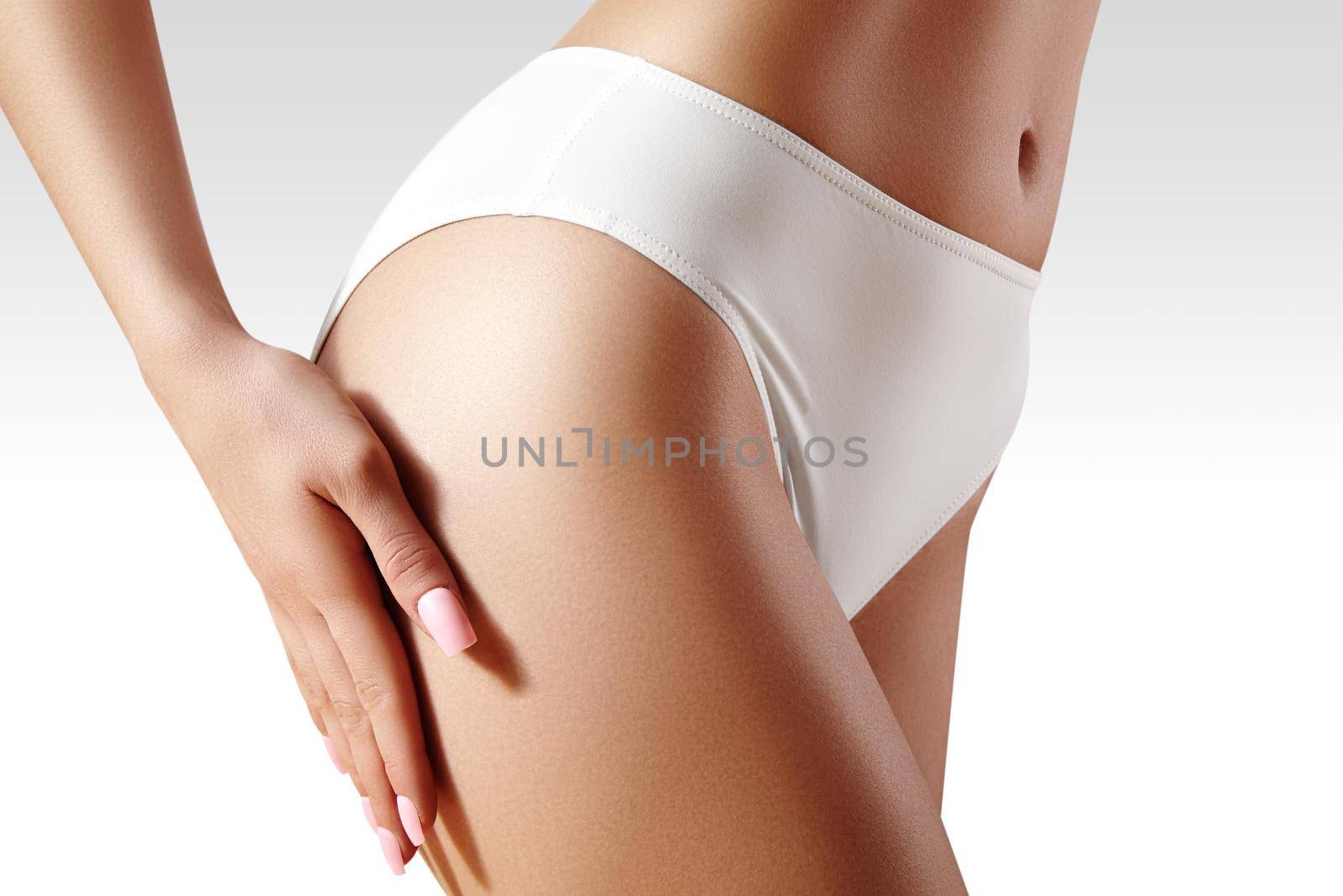 Spa and wellness. Healthy slim body in white panties. Beautiful sexy hips with clean skin. Fitness or plastic surgery. Perfect buttocks without cellulite.