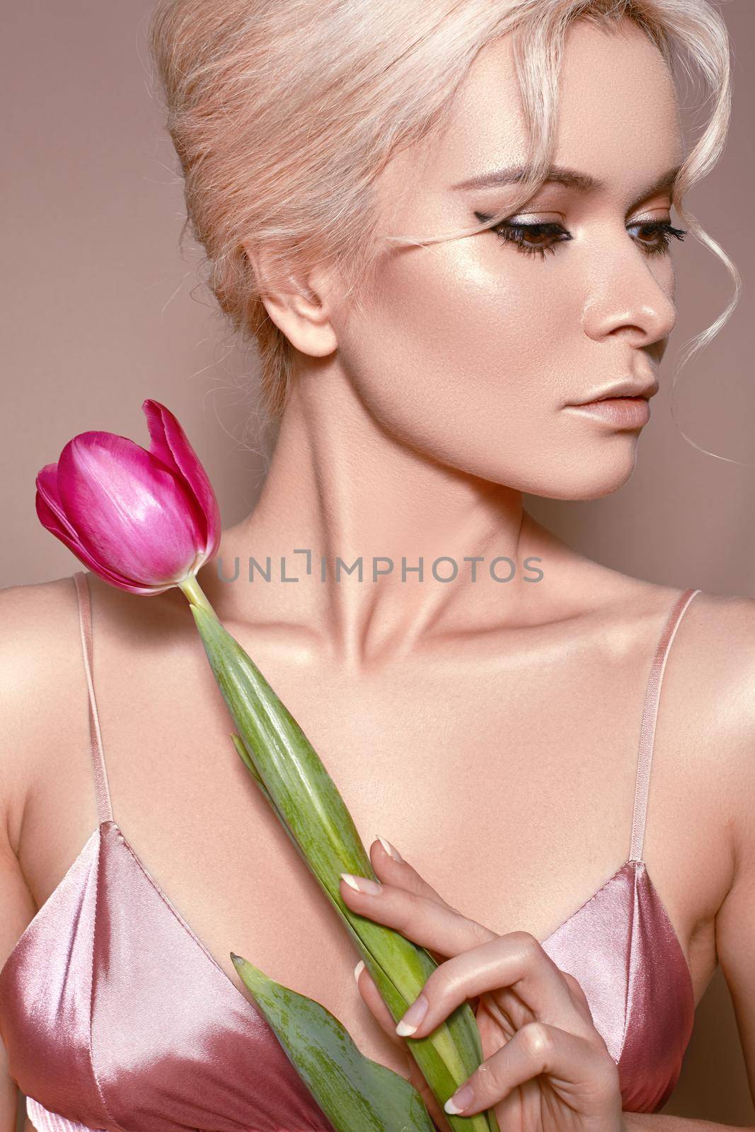 Beautiful sexy Blonde Woman with luxury retro Make-up. Girl with Spring Flowers Bouquet on Beige Background for any Celebrating. Fresh Style for Womans Day or Valentines