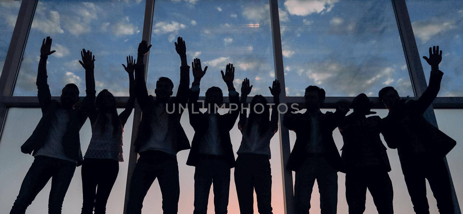 silhouette of a group of business people raising their hand by asdf