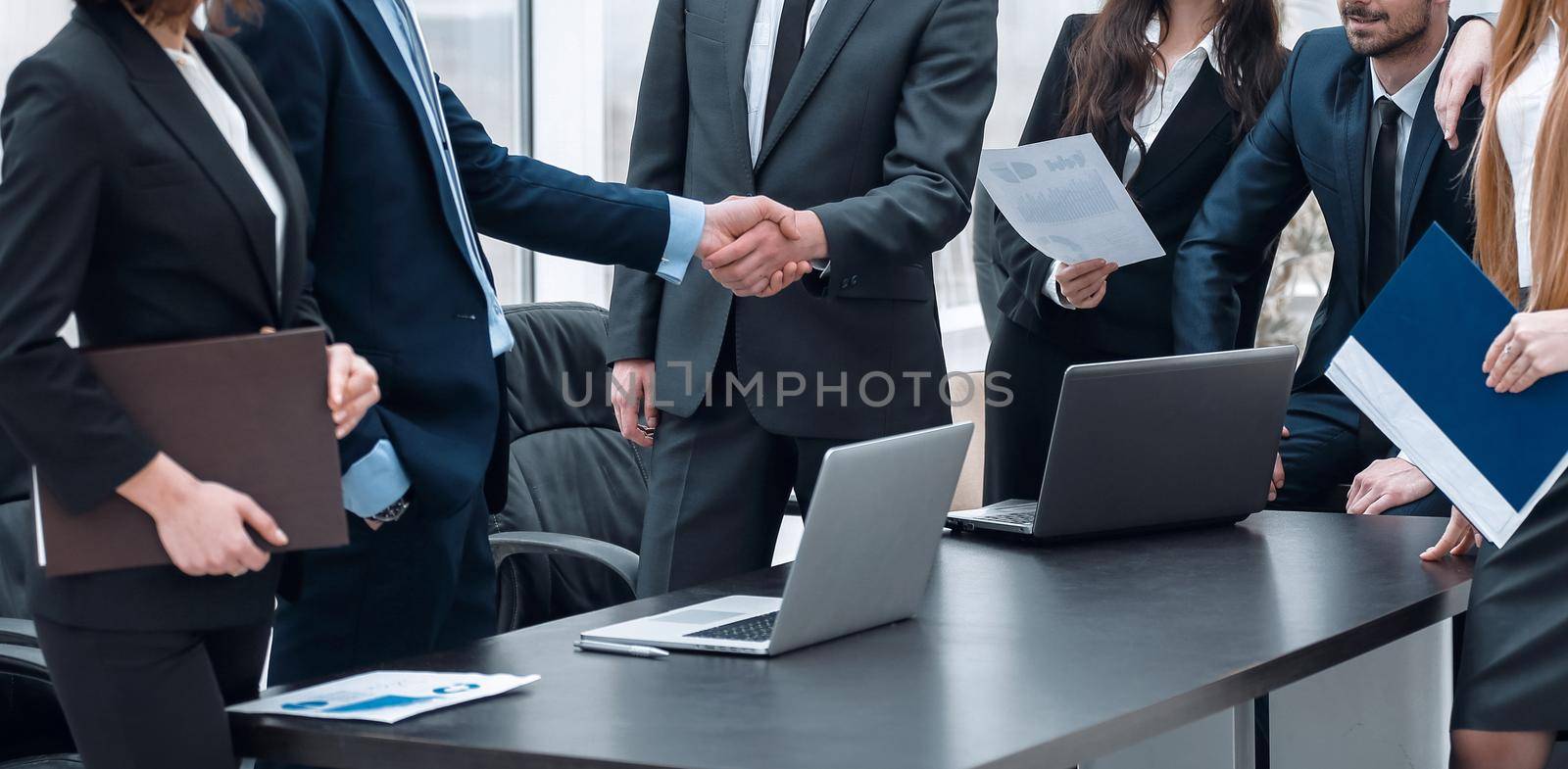 handshake business partners at a meeting in the office by asdf