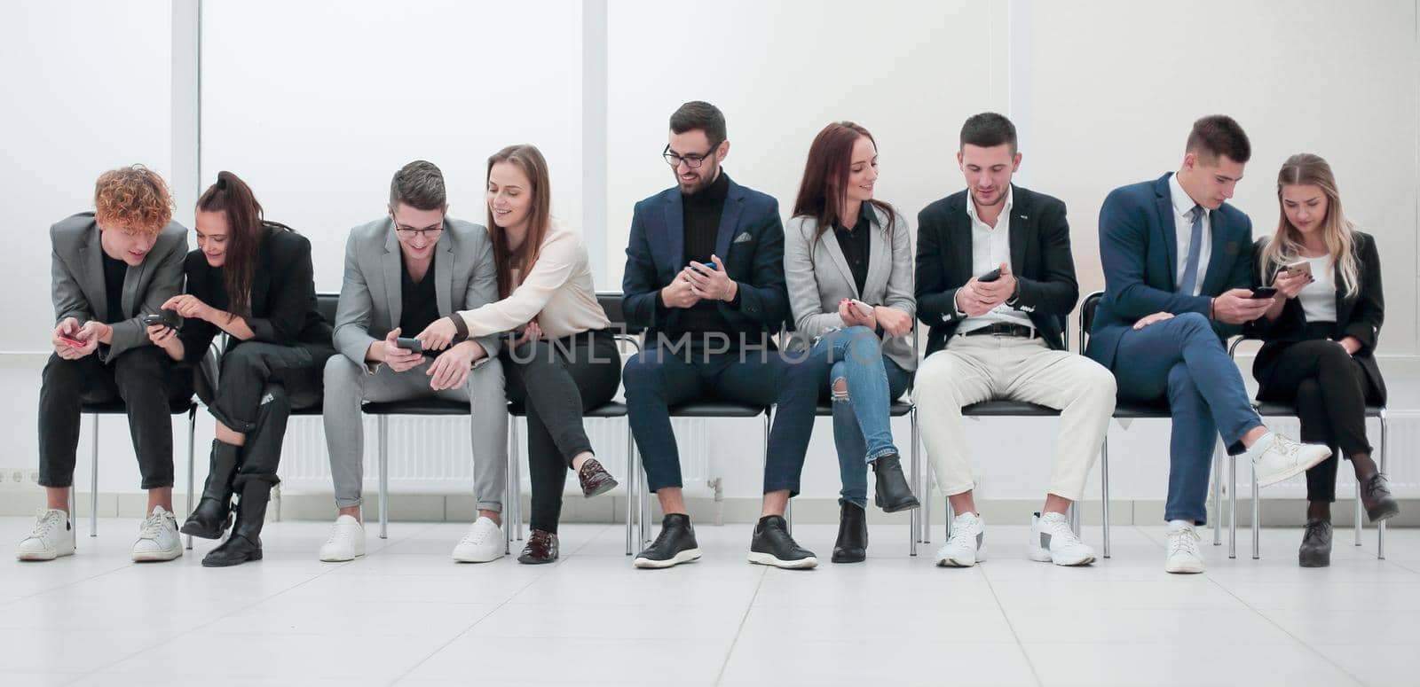 group of diverse young business people looking at their smartphone screens. photo with copy space